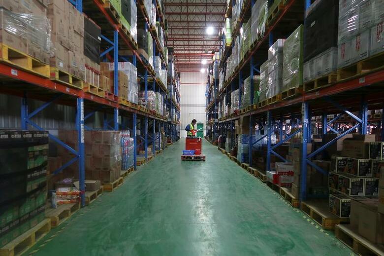 １月２９日、流通業界では、人口知能（ＡＩ）とロボットを組み合わせた省力化投資がにわかに動きを強めている。景気拡大やネット通販拡大に加えて働き方改革の影響もあり、人手不足に拍車がかかり、手をこまねいていては事業拡大もままらない状況がある。写真は中国の物流倉庫内で商品を探す従業員。昨年１１月、上海で撮影（２０１８年　ロイター／Brenda Goh）