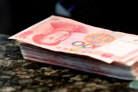 中国国営メディアによると、同国の複数の都市が不動産支援策の一環で住宅ローン金利と頭金比率を引き下げた。写真は１００人民元札、２０１６年３月撮影（２０２４年　ロイター／Kim Kyung-Hoon）