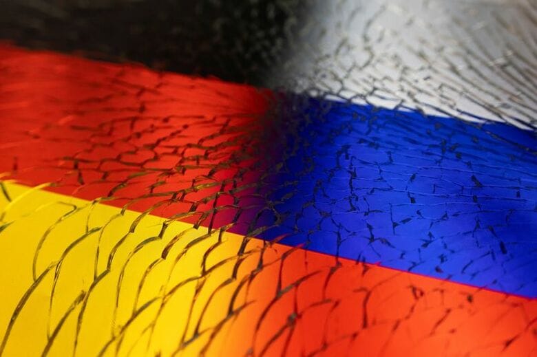 写真は割れたガラスと、ドイツとロシアの国旗イメージ。2022年4月撮影。REUTERS/Dado Ruvic