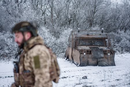 　１月２７日、トランプ米政権はウクライナに対して、米国による「安全の保証」提供はウクライナがまず、ドンバス地方のロシアへの割譲が盛り込まれた和平協定に合意することが条件になるとの考えを示唆したと、英紙フィナンシャル・タイムズ（ＦＴ）が、関係者８人の話として報じた。写真は、ロシアのウクライナ侵攻が続くドネツク州の戦線近くの訓練場で、軍用車両の横を歩くウクライナの兵士。２２日撮影（２０２６年　ロイター/Serhii Korovainyi）