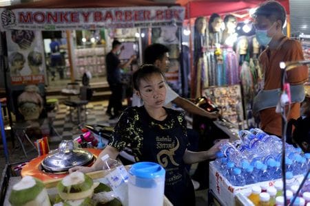 　タイの首都・バンコクで観光名所の１つになっているのがカオサン通り。いつもの週末は多くの人がひしめき、安いビール酒場やタトゥーショップ、屋台、宿泊施設、エネルギッシュな「夜の店」を目当てに、貧乏旅行者や団体客も訪れる。写真はカオサン通りで客が来るのを待つ人。３月１２日撮影（２０２０年　ロイター/Jorge Silva）