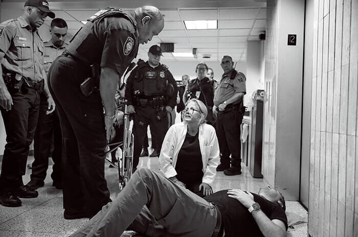 移民拘束の瞬間を記録しようとして捜査官に突き飛ばされ頭を打ったジャーナリストのL・ブラル・エリボルを診る医師。当局はこの後、ジャーナリストらに、いかなる妨害行為も逮捕につながると警告した