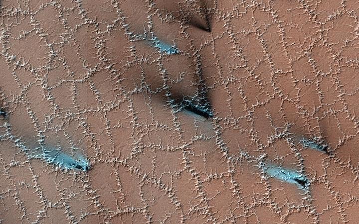「地表を覆う透明なドライアイスの層に噴気孔が空き、ガスの逃げ道をつくる」......　credit: NASA/JPL-Caltech/UArizona