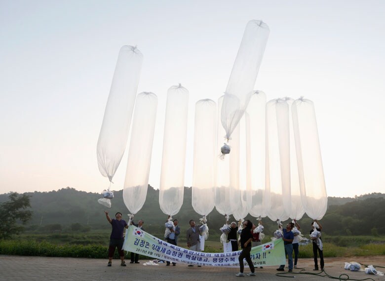 北朝鮮から韓国だけでなく、韓国側からの宣伝攻撃も激化しており、「5月までに1000万枚（のビラ）を飛ばす」と話す対北朝鮮団体関係者もいる（写真は2013年、北朝鮮との軍事境界線近くで北の体制批判のビラに加え、石鹸、靴下、コンドーム、歯ブラシなどを梱包して風船で飛ばす市民団体メンバー）　Lee Jae-Won-REUTERS