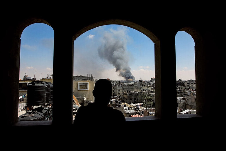イスラエル軍が作戦を展開しているラファ東部を見るパレスチナ人男性（5月7日）　HATEM KHALEDｰREUTERS