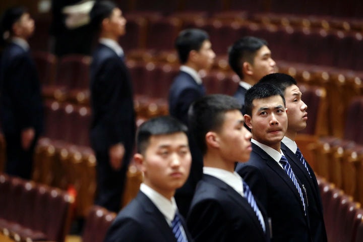 中国人民政治協商会議が行われた北京の人民大会堂で監視にあたる警備員（3月3日）　Jason Lee-REUTERS