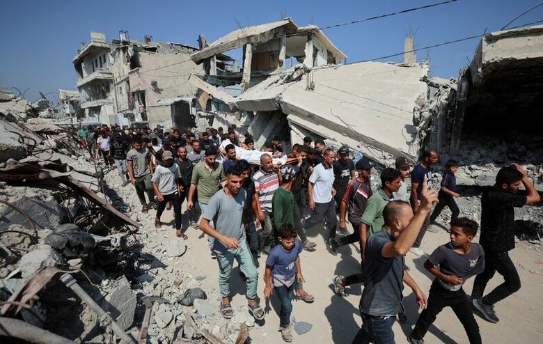 イスラエル軍の攻撃で死亡した人の遺体を運ぶ様子。パレスチナ自治区ガザで今月１６日撮影。REUTERS/Dawoud Abu Alkas