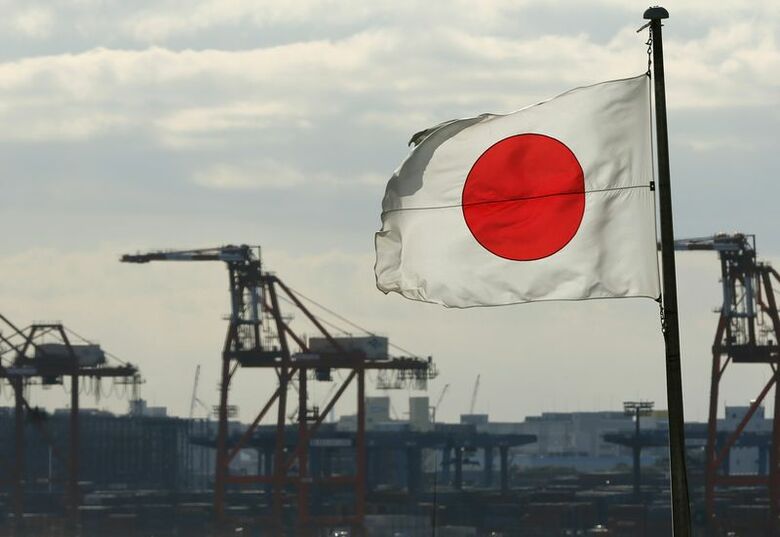 写真は日本国旗と都内のコンテナ港。2012年12月撮影。REUTERS/Yuriko Nakao