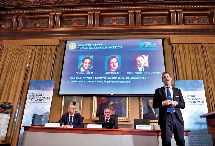 10月14日の授賞者発表の模様。スクリーンの写真で中央のデュフロは史上最年少の受賞者だ　TT NEWS AGENCY-REUTERS