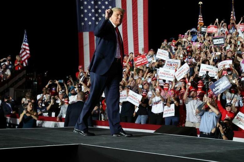トランプ米大統領は12日、今月2日に新型コロナウイルス感染を公表して以来初となる選挙集会をフロリダ州の空港で開いた。マスクは着用せず、感染が拡大するコロナへの対応を自画自賛した。写真は同空港の集会場でポーズを取るトランプ氏。(2020年　ロイター/Jonathan Ernst)