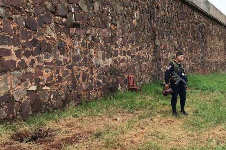 1月19日早朝、パラグアイ史上最大規模の脱獄事件が起きた。写真は脱獄囚が堀った穴の傍らに立つ警備員。1月22日、ペドロ・ファン・カバリェロで撮影（2020年　ロイター/Gabriel Stargardter）