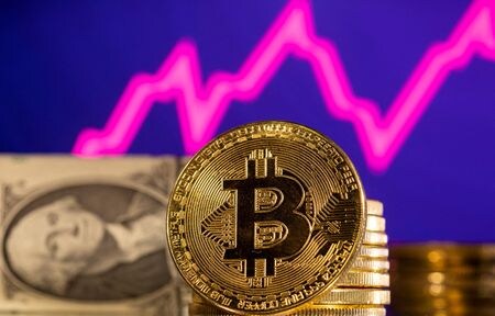 　３月３１日、  米金融市場で個人投資家が再び活気付き、「ミーム株」から仮想通貨（暗号資産）に至るまで、リスク資産を買い上げている。写真は暗号資産とドルのイメージ。１月撮影（２０２２年　ロイター/Dado Ruvic）