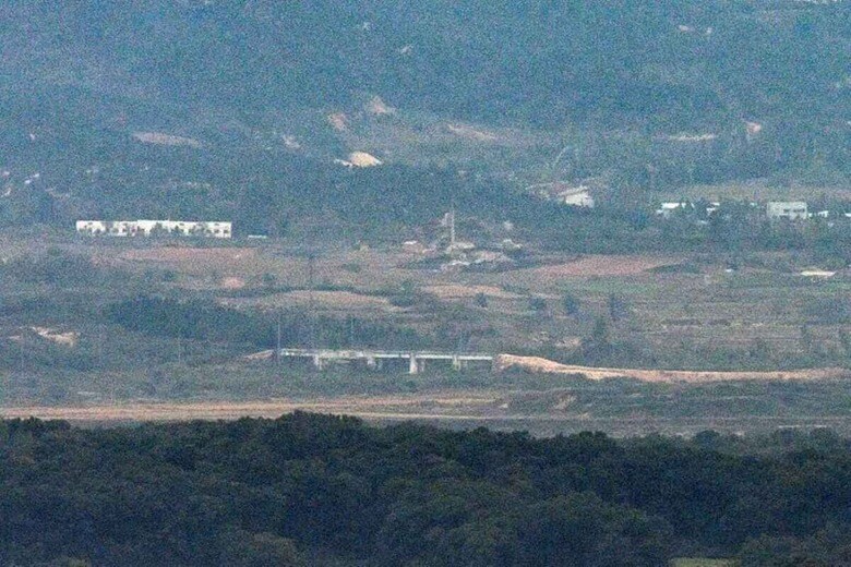 韓国軍合同参謀本部は１５日、北朝鮮が南北道路の一部を爆破したと明らかにした。写真は韓国の坡州市から１４日に撮影された南北を隔てる非武装地帯（DMZ）北部の京義線道路にある構造物の近くに積み上げられた土の山。聯合ニュース（２０２４年　ロイター）
