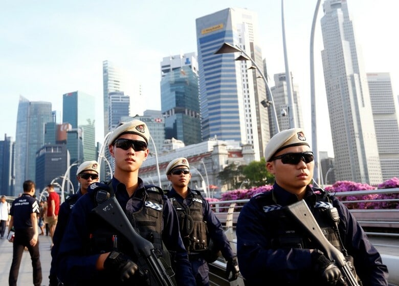 １０日、シンガポールの市街地を警備する警察官（２０１８年　ロイター/Feline Lim）