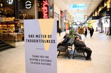 スウェーデンのロベーン首相は２４日、一部地域における新型コロナウイルスの感染ペースに懸念を示し、多くの人たちが数カ月にわたる警戒態勢を緩め、元の社会生活に戻りたくなっているようだと指摘した。写真は5月、ストックホルムのショッピングセンター内でソーシャルディスタンスを呼びかける看板。提供写真（2020年  ロイター/TT News Agency/Henrik Montgomery)