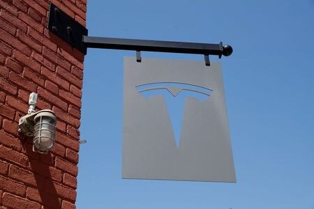 ５月１２日、米電気自動車（ＥＶ）大手テスラのマスク最高経営責任者（ＣＥＯ）は１２日、完全自動運転（ＦＳＤ）ソフトウエアが抱えるブレーキ関連の問題の修正作業を現在進めており、数カ月中に相当改善したベータ版を配布できる可能性があると明らかにした。写真はテスラのロゴ。ニューヨーク・ブルックリンのディーラーで４月撮影（２０２１年　ロイター/Shannon Stapleton）