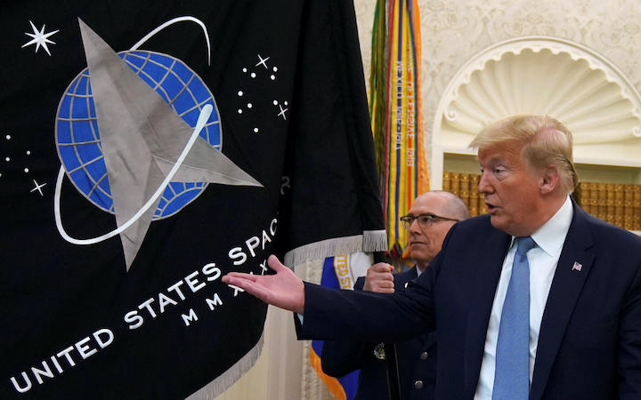 ホワイトハウスで新設された宇宙軍の軍旗を披露するトランプ（2020年5月15日）Kevin Lamarque -REUTERS