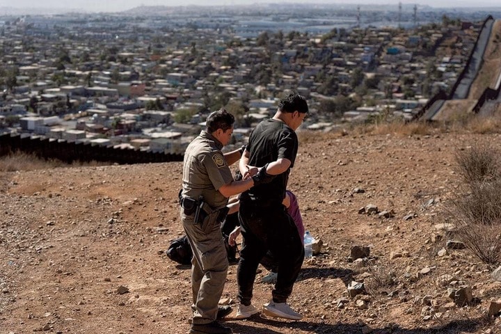 南部国境で違法入国を図った男を連行する米国境警備隊