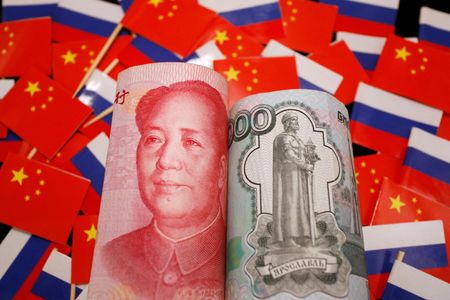 　７月１２日、中国税関総署が公表した統計によると、６月の同国のロシア向け輸出は人民元ベースで前年同月比４．７６％増え、５月の同０．９２％増から伸びが加速したものの、年初の２桁増には届いていない。写真は中国とロシアの国旗と、人民元とロシア・ルーブル紙幣。２０２２年９月撮影（２０２４年　ロイター/Florence Lo）