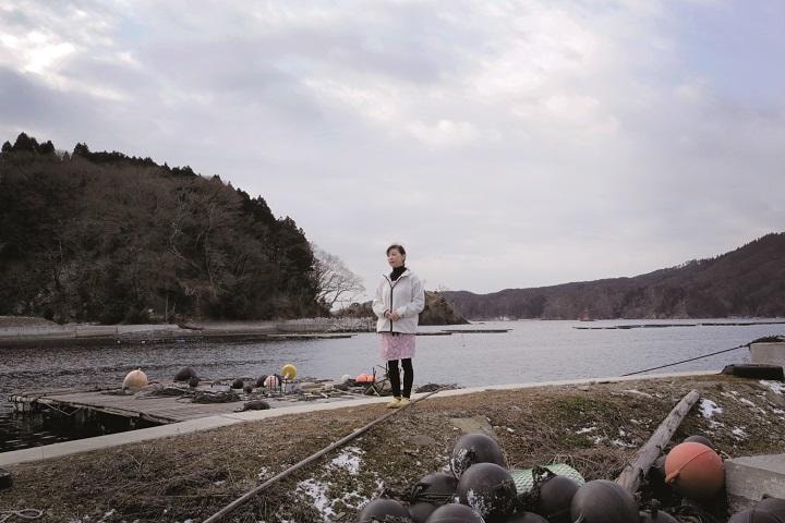 唐桑地区の鮪立港に立つ菅野一代。この静かな海があの日、津波となって集落を襲い、菅野はここにあった仕事場を失った　PHOTOGRAPH BY KOSUKE OKAHARA FOR NEWSWEEK JAPAN
