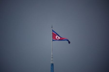 １１月４日、 ワシントンに拠点を置き北朝鮮の動向を監視しているシンクタンク「３８ノース」は４日、商用衛星画像の分析結果として、北朝鮮からロシア国内に列車が到着したと明らかにした。写真は北朝鮮の旗。韓国側から７月代表撮影（２０２２年　ロイター）
