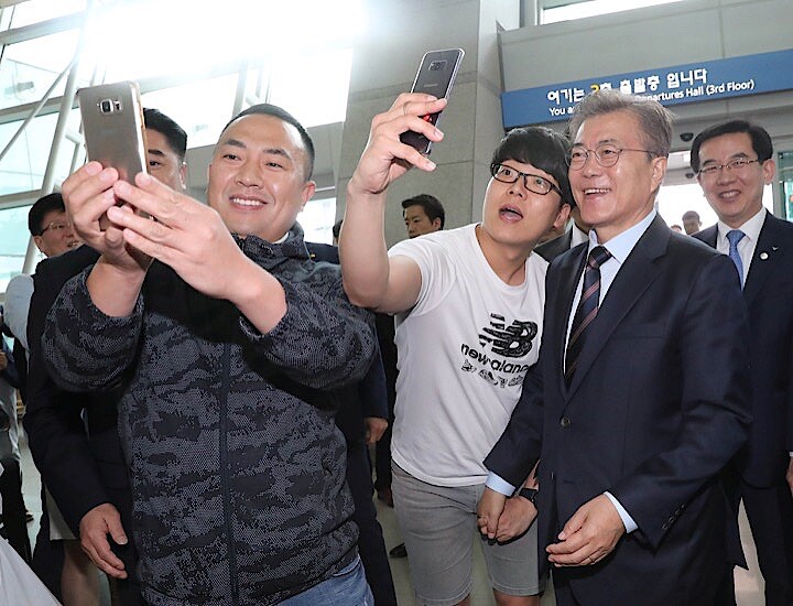 仁川空港を訪れた文在寅大統領は、通りがかった市民のセルフィーの求めに応じた　Stringer- REUTERS