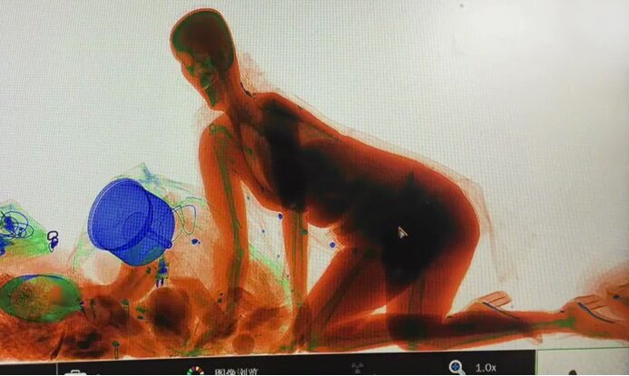 ハンドバッグと一緒にX線検査機の中へ入った女性 PearVideo-Facebook