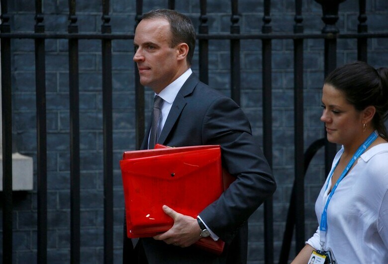 11月15日、英国のラーブ欧州連合（EU）離脱担当相（写真中央）は、メイ首相の離脱協定案に抗議し、辞任した。ロンドン市内で14日撮影（2018年　ロイター/Henry Nicholls）