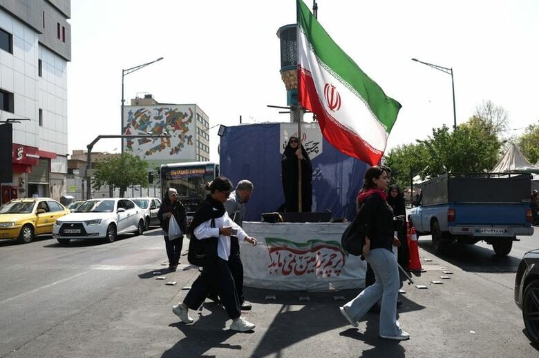 イラン国旗を掲げる女性。テヘランで10日撮影の低居写真。Majid Asgaripour/WANA (West Asia News Agency) via REUTERS