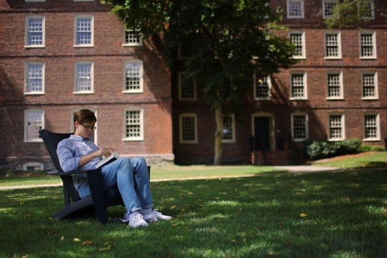 米国の大学から送られてくる合否通知の開封の場面を自撮りして、動画をネットで公開したい──。写真は16日、米ロードアイランド州プロビデンスのブラウン大で読書するウクライナからの留学生（2022年　ロイター/Brian Snyder）