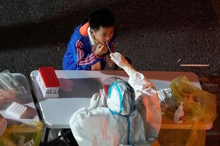 　中国当局は新型コロナウイルス対策でもっと的を絞ったアプローチを取り、「過度な措置」は是正すべきと、国営新華社通信が１０日報じた。写真は上海で９日、検査を受ける少年（２０２２年　ロイター／Aly Song）