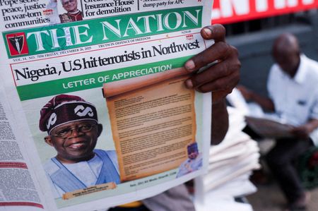 　ナイジェリア国防当局の報道官は、イスラム過激派の掃討作戦を強化するため、米軍部隊約１００人がナイジェリアに到着したと述べた。写真はナイジェリアのイスラム過激派に対する米軍の空爆を報じる新聞を読む人々。昨年１２月撮影（２０２６年　ロイター/Sodiq Adelakun）