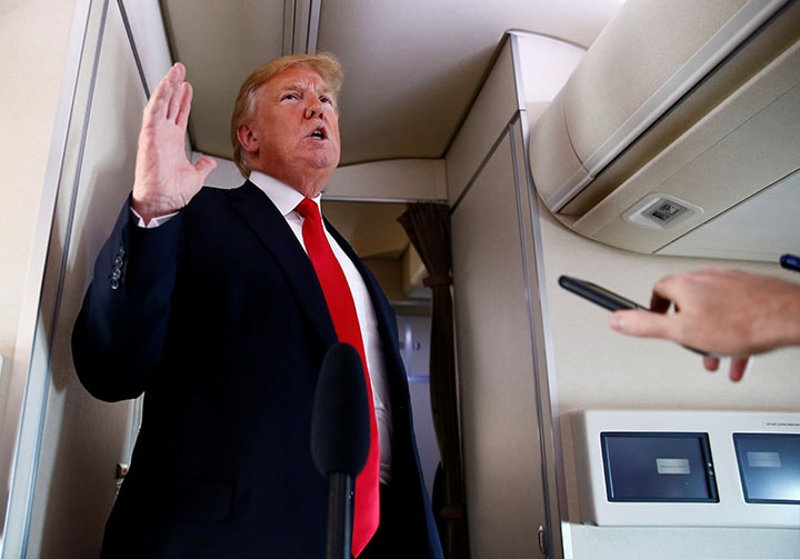 大統領専用機エアフォース・ワンで記者たちの質問に答えるトランプ　Eric Thayer-REUTERS