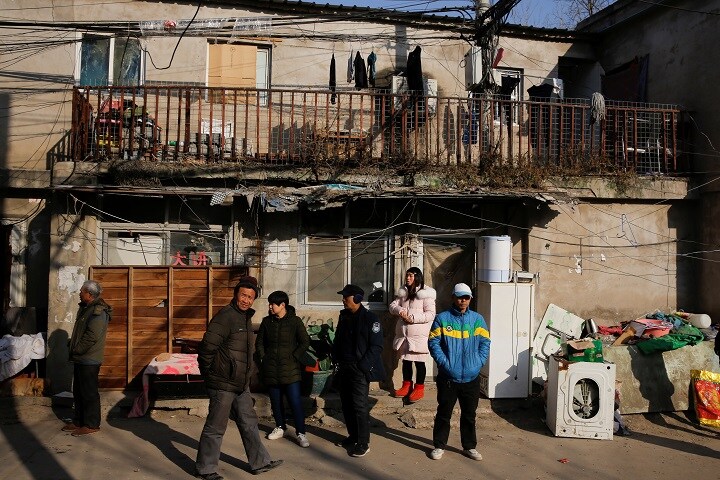 出稼ぎ労働者が多い新建村の住人。北京永住は許されず「どうせいつか追い出される」という気持ちから、少しぐらい危険な建物でも気にしない傾向がある（火災現場の近くで）　Thomas Peter- REUTERS