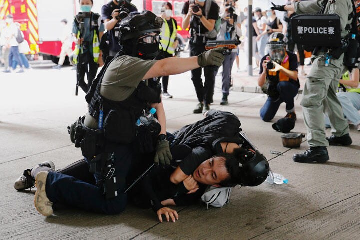警察官に身柄を拘束される香港のデモ参加者（7月1日）　Tyrone Siu-REUTERS
