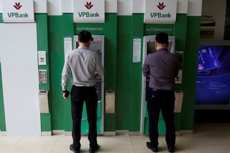 　３月２７日、ベトナムのベトナム・プロスペリティー・ジョイント・ストック・コマーシャル・バンク（ＶＰバンク）は、持ち分の１５％にあたる１５億ドル相当（約２０００億円）を三井住友フィナンシャルグループに売却したと発表した。写真はＶＰバンクのＡＴＭを使用する人々。２０１７年１１月、ハノイで撮影（２０２３年　ロイター/Kham）