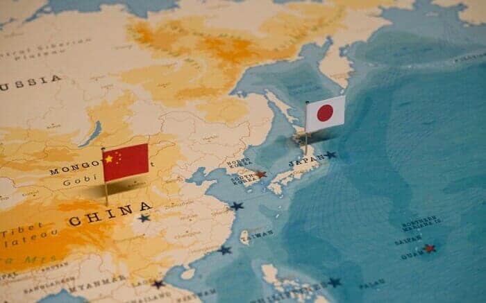 中国国旗と日本国旗の刺さった世界地図