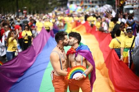 ７月２日、英ロンドンで１９７２年の初回から５０回目となるＬＧＢＴＱ＋（性的少数者）の権利を訴える「プライド」パレードが行われ、カーン市長によれば過去最多の１００万人以上の見物人が市中心部に詰めかけた。写真はキスするロンドンのプライドパレード参加者（２０２２年　ロイター/Henry Nicholls）