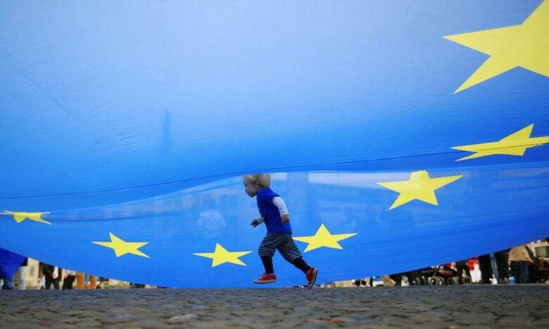 ＥＵの旗の下を通り抜ける子ども。2019年9月7日、ドイツ・ベルリンで撮影。REUTERS/Hannibal Hanschke/File Photo