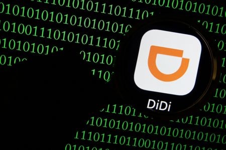 中国国家インターネット情報弁公室（ＣＡＣ）は１９日、外国資本を求める国内企業を支援すると表明し、企業の保有データが外国政府に悪用されるリスクの有無が審査の焦点になるとした。インターネットの発展に関する記者会見で述べた。写真は2021年7月撮影したパソコンに虫眼鏡越しに見えるディディのアプリロゴ（２０２２年　ロイター／Florence Lo）