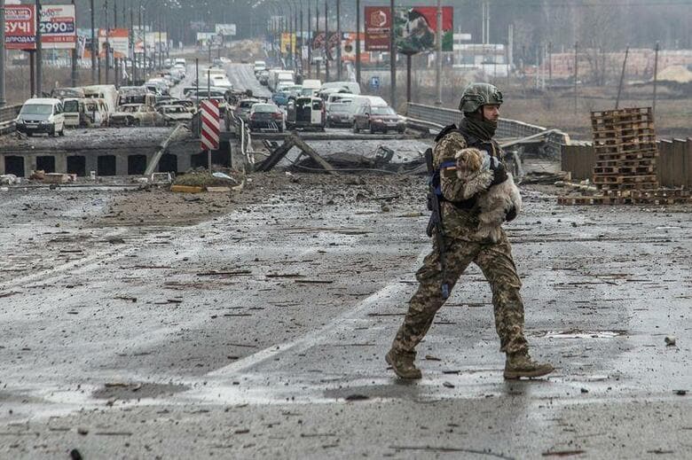 ウクライナ北部チェルニヒウの知事は、ロシア軍が撤退しつつあるが、完全撤退はしていないとし、砲撃などの可能性はまだあると述べた。写真は3月30日、イルピンで犬を運ぶウクライナ兵（2022年　ロイター/Oleksandr Ratushniak）