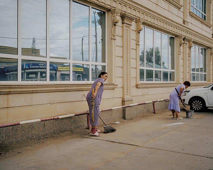 砂漠化が進むアティラウ州クルマンガジでほこりや砂の除去作業をする人々。呼吸器系の疾患も増えている