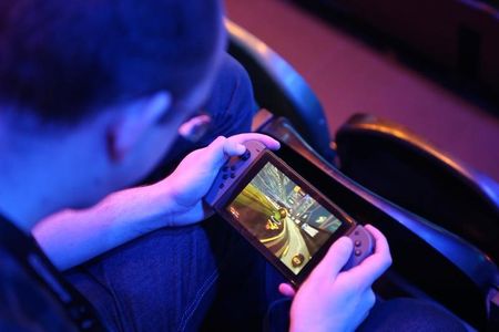 　新型コロナウイルスの影響による「巣ごもり」需要で活況となったゲーム市場は、来年もその勢いが持続するかが試される。写真はゲームで遊ぶ男性。ロンドンで２０１８年６月撮影（２０２１年　ロイター/Tom Jacobs）