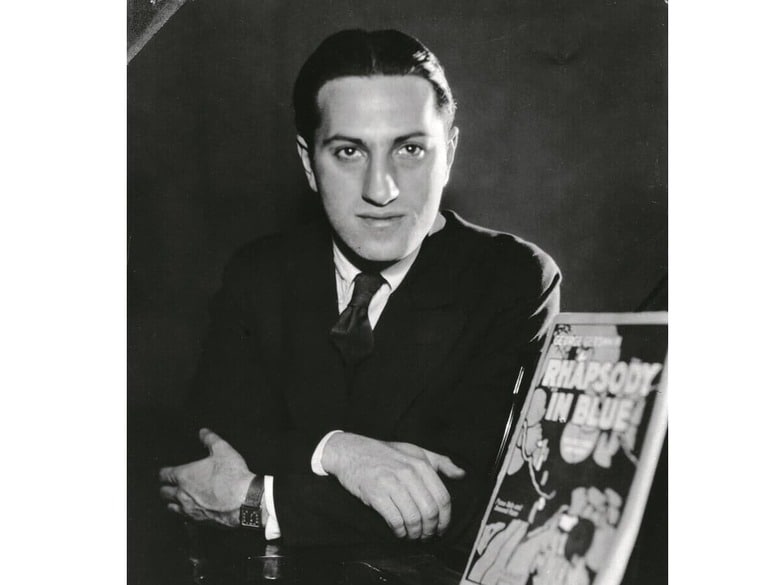 「ラプソディー・イン・ブルー」の楽譜を脇に、ガーシュウィンのポートレート　HULTON ARCHIVE/GETTY IMAGES