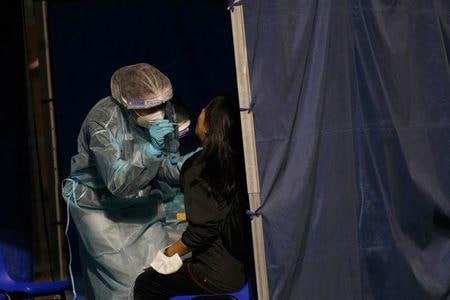 香港の衛生当局は、英国から香港に帰った学生２人が英国で感染が拡大している新型コロナウイルス変異種に感染したもようだと明らかにした。写真は香港のサッカー場で検査を受ける女性。８日撮影（２０２０年　ロイター/Lam Yik）