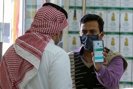 入国制限の緩和に動くサウジアラビアは２０日から、新型コロナウイルスの水際対策として、入国する外国人に政府指定の施設で１週間の隔離を義務付ける。同国民間航空総局（ＧＡＣＡ）が１０日に発表した。写真は、リヤド市内で携帯電話に表示されたコロナ感染者追跡アプリの内容を提示する男性。２０２１年２月２２日に撮影。（２０２１年　ロイター／hmed Yosri）