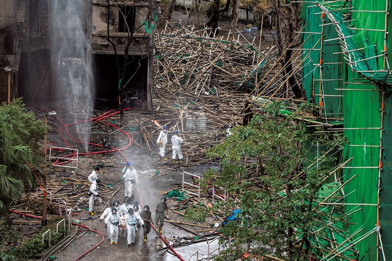 火災現場から遺体を運び出す消防隊。安全基準を満たさない資材が延焼を招いたとされる　VERNON YUENｰNEXPHER IMAGESｰSIPA USAｰREUTERS