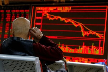 　国際金融協会（ＩＩＦ）が１０月５日公表した非居住者資金動向によると、９月は新興国市場から２９億ドルが流出し、この８か月間で７カ月目の売り越しとなった。写真は上海の証券会社の店舗で株価チャートを見る人。２０１８年１２月撮影（２０２２年　ロイター/Thomas Peter）