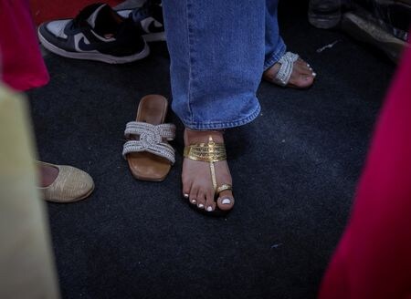 イタリアの高級ファッションブランド、プラダがインドの伝統的なサンダル「コルハプリ」（ヒンドゥー語ではチャッパル）のデザインを無断で使用したと激しい批判を浴びた。写真はコルハプリを試す女性。７月１日、ニューデリーで撮影（２０２５年　ロイター/Bhawika Chhabra）