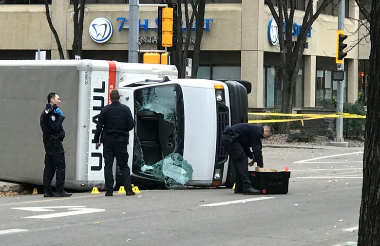 １０月１日、カナダ西部アルバータ州の州都エドモントンで９月３０日夜、男が警官１人を車ではねた後にナイフで刺し、その後逃走中に通行人４人に車を突っ込んで負傷させた事件で、カナダ連邦警察は、殺人未遂容疑で容疑者のソマリア難民男性を訴追した。写真は事件を起こした車両を捜査する警察官たち。エドモントンで撮影（２０１７年　ロイター／Candace Elliott）